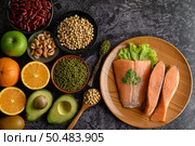 Legumes, fruit and salmon pieces on a wooden plate. Стоковое фото, агентство Ingram Publishing / Фотобанк Лори