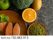 Legumes, fruit and salmon pieces on a wooden plate. Стоковое фото, агентство Ingram Publishing / Фотобанк Лори