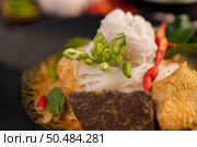Chicken curry in a black cup with rice noodles, garlic, tomatoes, chilies, and kaffir lime leaves. Стоковое фото, агентство Ingram Publishing / Фотобанк Лори