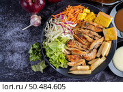 Sliced ??chicken steak with bread, carrots, cauliflower, turnips, and corn on a black plate on a cement floor. Стоковое фото, агентство Ingram Publishing / Фотобанк Лори