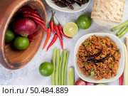 Spicy pork chops in a white dish consisting of lemons, chilies, and side dishes. Selective focus. Стоковое фото, агентство Ingram Publishing / Фотобанк Лори