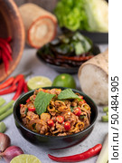 Spicy pork chops in a black cup consisting of lemons Chili and side dishes. Selective focus. Стоковое фото, агентство Ingram Publishing / Фотобанк Лори