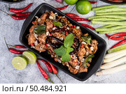 Spicy pork chops on a black plate consisting of lemons Chili and side dishes. Selective focus. Стоковое фото, агентство Ingram Publishing / Фотобанк Лори