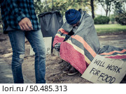 Beggars wrapped in cloth and then put on a hat and sat down beside the street and someone gave money. Стоковое фото, агентство Ingram Publishing / Фотобанк Лори