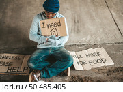 Beggars sitting under the bridge with a sign, please home. Стоковое фото, агентство Ingram Publishing / Фотобанк Лори