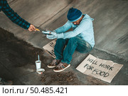 Beggars sitting under the overpass with a credit card and credit card swipe machine. Стоковое фото, агентство Ingram Publishing / Фотобанк Лори