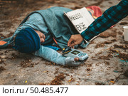Beggars sitting under the overpass with a credit card and credit card swipe machine. Стоковое фото, агентство Ingram Publishing / Фотобанк Лори
