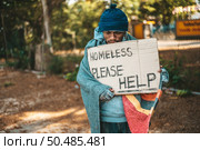 Beggars stand on the street with homeless messages please help. Стоковое фото, агентство Ingram Publishing / Фотобанк Лори