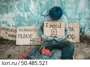 The beggars sat beside the street with a homeless message. Please help and work with food. Стоковое фото, агентство Ingram Publishing / Фотобанк Лори