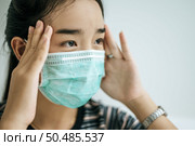 Woman wearing a striped shirt, wearing a mask and a handle on the tail of the eyebrows. Стоковое фото, агентство Ingram Publishing / Фотобанк Лори