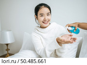 Young women clean their hands with a hand wash gel to prevent germs. Стоковое фото, агентство Ingram Publishing / Фотобанк Лори