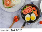 Boiled eggs, carrots, and tomatoes on a pan with tomato on a wooden spoon. Стоковое фото, агентство Ingram Publishing / Фотобанк Лори