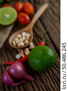 Thai style spicy food, Som Tum food concept, props decoration Garlic, lemon, peanuts, tomatoes, and shallots on wood table. Стоковое фото, агентство Ingram Publishing / Фотобанк Лори