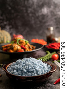 Butterfly Pea flower rice in a brown cup with spices on black cement. Стоковое фото, агентство Ingram Publishing / Фотобанк Лори
