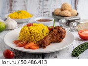 Chicken Biryani in a plate with spices on a white wooden floor. Стоковое фото, агентство Ingram Publishing / Фотобанк Лори