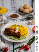 Chicken Biryani in a plate with spices on a white wooden floor. Стоковое фото, агентство Ingram Publishing / Фотобанк Лори