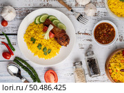 Chicken Biryani in a plate with spices on a white wooden floor. Стоковое фото, агентство Ingram Publishing / Фотобанк Лори