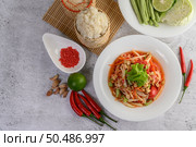 Thai papaya salad in a white plate with Sticky rice in wicker basket bamboo and dried shrimp. Стоковое фото, агентство Ingram Publishing / Фотобанк Лори