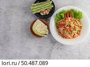 Thai papaya salad in a white plate with Yardlong beans, garlic, and Collard white. Top view. Стоковое фото, агентство Ingram Publishing / Фотобанк Лори