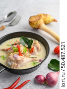 Tom Kha Kai in a pan frying with kaffir lime leaves, lemongrass, red onion, galangal and chilli.Selective focus. Стоковое фото, агентство Ingram Publishing / Фотобанк Лори