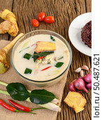Tom Kha Kai in a bowl with kaffir lime leaves, lemongrass, red onion, galangal and chilli. Стоковое фото, агентство Ingram Publishing / Фотобанк Лори
