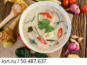 Tom Kha Kai in a bowl with kaffir lime leaves, lemongrass, red onion, galangal and chilli. Стоковое фото, агентство Ingram Publishing / Фотобанк Лори