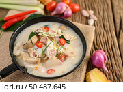 Tom Kha Kai in a pan frying with kaffir lime leaves, lemongrass, red onion, galangal and chilli. Стоковое фото, агентство Ingram Publishing / Фотобанк Лори