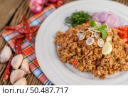 Spicy Minced Pork Salad on a white plate with red onion, lemon grass, garlic, yardlong beans, kaffir lime leaves, and spring onion. Стоковое фото, агентство Ingram Publishing / Фотобанк Лори