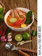 Tom Yum Kung Thai hot spicy soup shrimp with lemon grass,lemon,galangal and chilli on wooden background Thailand Food. Стоковое фото, агентство Ingram Publishing / Фотобанк Лори