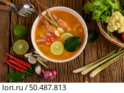Tom Yum Kung Thai hot spicy soup shrimp with lemon grass,lemon,galangal and chilli on wooden background Thailand Food. Стоковое фото, агентство Ingram Publishing / Фотобанк Лори