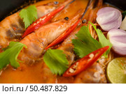 Tom Yum Kung Thai hot spicy soup shrimp with lemon grass,lemon,galangal and chilli on wooden background Thailand Food. Стоковое фото, агентство Ingram Publishing / Фотобанк Лори