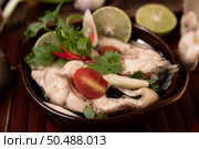 Boil the fish infusion with tomatoes, mushrooms, coriander, spring onion and lemongrass in a bowl. Стоковое фото, агентство Ingram Publishing / Фотобанк Лори