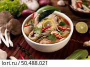 Boil the fish infusion with tomatoes, mushrooms, coriander, spring onion and lemongrass in a bowl. Стоковое фото, агентство Ingram Publishing / Фотобанк Лори