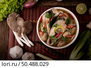 Boil the fish infusion with tomatoes, mushrooms, coriander, spring onion and lemongrass in a bowl. Стоковое фото, агентство Ingram Publishing / Фотобанк Лори