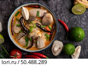 Tom yum chicken with chili, coriander, dried chili, kaffir lime leaves, mushroom and lemongrass in a bowl. Стоковое фото, агентство Ingram Publishing / Фотобанк Лори