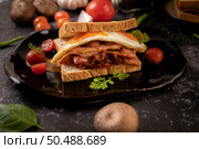 Breakfast sandwich made with bread, fried egg, ham, and lettuce. Стоковое фото, агентство Ingram Publishing / Фотобанк Лори