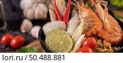 Tom Yum Kung in a bowl with tomato, chili, lemongrass, garlic, lemon, and kaffir lime leaves. Стоковое фото, агентство Ingram Publishing / Фотобанк Лори
