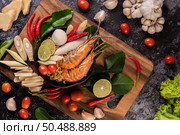 Tom Yum Kung in a bowl with tomato, chili, lemongrass, garlic, lemon, and kaffir lime leaves. Стоковое фото, агентство Ingram Publishing / Фотобанк Лори