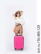 Woman wearing a hat, glasses, and handles of suitcases to travel. Стоковое фото, агентство Ingram Publishing / Фотобанк Лори