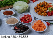 Diced carrots, dried chilies, roasted rice, chili, and cabbage are placed on a cement floor. Стоковое фото, агентство Ingram Publishing / Фотобанк Лори