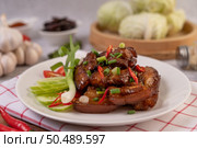 Sweet pork on a white plate with chopped scallions, chili, lime, cucumber, tomato, and garlic. Стоковое фото, агентство Ingram Publishing / Фотобанк Лори