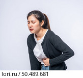 A woman standing with a stomach ache and presses her hand on her stomach. Стоковое фото, агентство Ingram Publishing / Фотобанк Лори