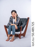 The woman was sick, sat on a chair, and touched her head with her hand. Стоковое фото, агентство Ingram Publishing / Фотобанк Лори