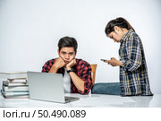 Women teach men how to work with laptops at work. Стоковое фото, агентство Ingram Publishing / Фотобанк Лори