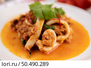 Stir-fried squid with curry powder in white plate. Стоковое фото, агентство Ingram Publishing / Фотобанк Лори