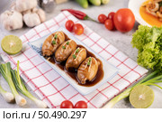 Squid stuffed with pork in black sauce in white plate. Стоковое фото, агентство Ingram Publishing / Фотобанк Лори