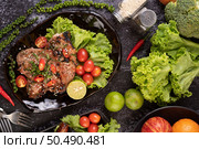 Sliced ??pork steak topped with white sesame and fresh pepper seeds along with tomatoes, lemons, chili and lettuce. Стоковое фото, агентство Ingram Publishing / Фотобанк Лори