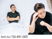 A woman who loves each other gets angry and sits on the bed. Стоковое фото, агентство Ingram Publishing / Фотобанк Лори