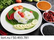 ?Rice noodles in a banana leaf with beautifully laid vegetables and side dishes. Thai food. Стоковое фото, агентство Ingram Publishing / Фотобанк Лори