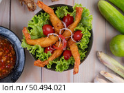 Shrimp deep fried batter placed on salad and tomatoes in a wooden bowl. Стоковое фото, агентство Ingram Publishing / Фотобанк Лори